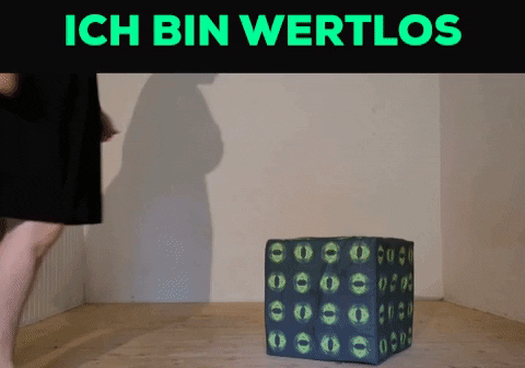 Ein Gif. Oben in Knallgrün auf Schwarzem Grund die Worte: ich bin wertlos. Darunter versucht Tristan Marie tritt gegen einen würfelförmigen Polsterhocker. Der Hocker fliegt durch den Raum.